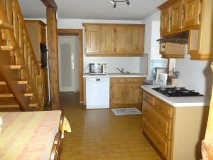 a kitchen with wooden cabinets and a stove top oven at Gîte Les Hambostures in Lapoutroie