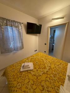 a bedroom with a yellow bed with a towel on it at M&M Rooms in Pannocchia