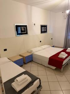 a room with two beds and a tv on the wall at M&M Rooms in Pannocchia +12 photos