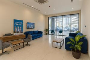 a living room with a blue couch and chairs at Panorama Central Batumi in Batumi