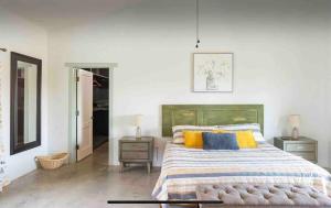 a bedroom with a bed with yellow and blue pillows at La Casa Del Valle in Francisco Zarco