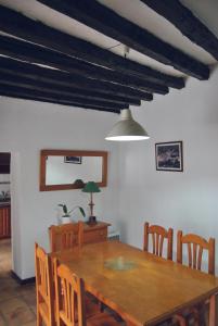 a dining room with a wooden table and chairs at Casa Rural El Palmar in Vallehermoso