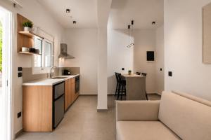 a kitchen and living room with a couch and a table at Theros Luxury Apartment in Archangelos