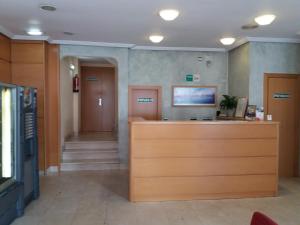 a waiting room with a reception desk in a hospital at Hotel Avenida in Gijón