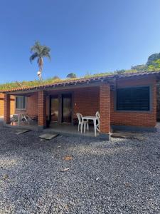 a brick house with a table and chairs in front of it at Chalés Talismã in Caconde