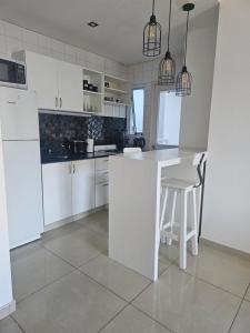 a white kitchen with a white counter and chairs at Palermo Apart 2 in Buenos Aires