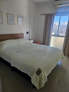 a large bed in a room with a window at Palermo Apart 2 in Buenos Aires
