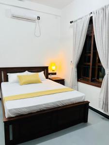 a bedroom with a large bed with a window at Luna Mara in Arugam Bay