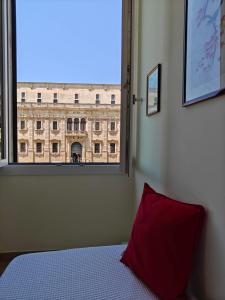 a bedroom with a window looking out at a building at Palazzo Lanzilao's Rooms in Lecce +29 photos