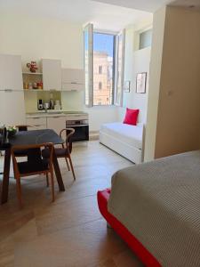 a room with a bed and a table and a kitchen at Palazzo Lanzilao's Rooms in Lecce