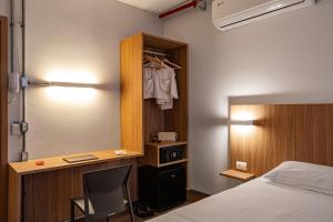 a bedroom with a bed and a desk with a chair at Moov Hotel São Paulo in São Paulo