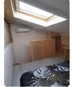 an attic room with a bed and a skylight at Duplex centre historique frejus in Fréjus
