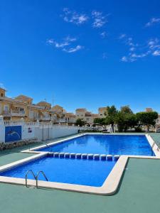 a large swimming pool with a blue sky in the background at ADA & Gran Alacant & Vacation in Gran Alacant