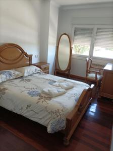 a bedroom with a large bed and a mirror at Refugio Mar de Boiro in Boiro
