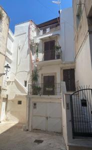 a white house with a garage and a balcony at Pikaret Bed&Breakfast in Corato +14 photos