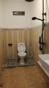 a bathroom with a toilet and a bath tub at USTIN Villas Lombok in Bumbang +34 photos