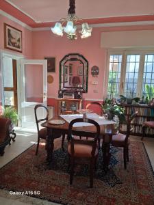 a dining room with a table and chairs and a mirror at Le Ortensie in Bono