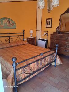a bedroom with a large bed with a dresser and a dresser at Le Ortensie in Bono