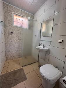 a bathroom with a toilet and a shower and a sink at Chalés Talismã in Caconde +63 photos