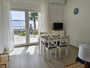 a dining room with a table and chairs with a view of the ocean at Beach House Adria in Bibinje