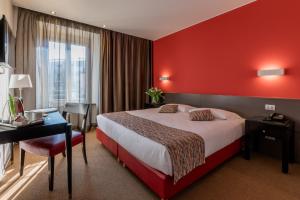 ヴィッラ・オピチーナにあるHotel Valeriaの赤い壁の大きなベッドが備わるホテルルームです。