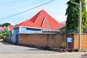 a red roofed house with a brick wall at Brabus Appartment Motel in Rubavu