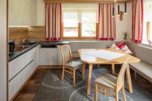a small kitchen with a wooden table and chairs at Haus-Elisabeth in Uderns