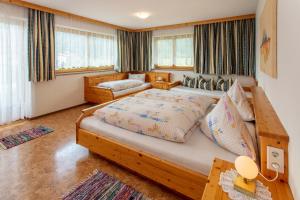 a bedroom with a large bed and a couch at Haus-Elisabeth in Uderns