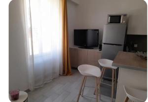 a kitchen with a refrigerator and a table and chairs at Duplex centre historique frejus in Fréjus