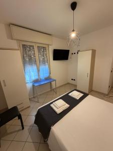 a bedroom with a bed with two towels on it at M&M Rooms in Pannocchia