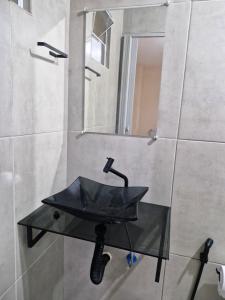 a bathroom with a glass sink and a mirror at Pousada Mar de Pajuçara in Maceió