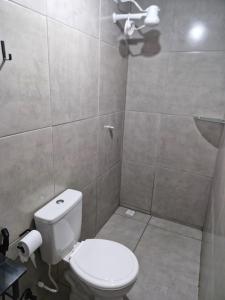a bathroom with a white toilet and a shower at Pousada Mar de Pajuçara in Maceió +28 photos