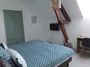 a bedroom with a blue bed and a desk at La Grange in Chérisy