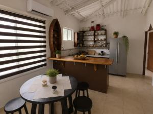 a kitchen with a table and chairs and a refrigerator at Hospedaje Isabela in Puerto Villamil