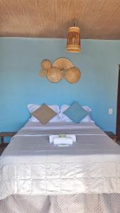 a bedroom with a bed with a blue wall at Pipa Centro in Pipa