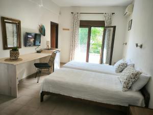 a bedroom with a bed and a desk with a computer at Pension Aldebaran in Potos