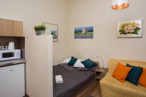 ブダペストにあるHome Apartment near Blaha Lujza Squareのベッド1台とソファが備わる小さな客室です。