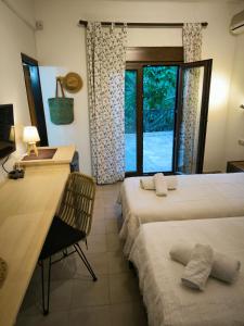 a bedroom with two beds and a desk and a window at Pension Aldebaran in Potos