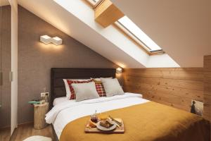 a bedroom with a bed with a tray of food on it at Apartament Stary Drewniany Białka Ski Resort -obok Termy Bania i Kotelnica in Białka Tatrzańska +34 photos