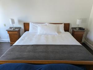 a bedroom with a large bed with two night stands at Auberge des 21 in La Baie