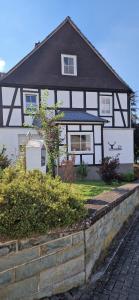 a white house with a black roof at LandHaus Hof Wehlenbach in Hallenberg