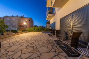 a stone patio with chairs and a building at Bonavita Zaton in Zaton