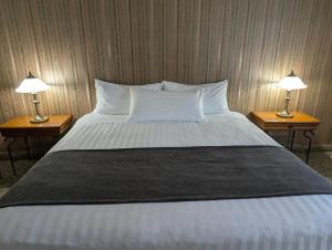 a bedroom with a large bed with two lamps at Auberge des 21 in La Baie