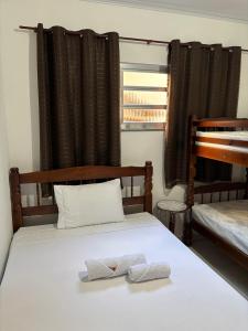 a bedroom with two bunk beds with towels on the bed at Casa Zago 1 in Santa Maria Madalena