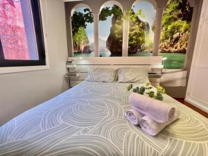 a bedroom with a bed with two towels on it at Casa baja a la playa in Bueu