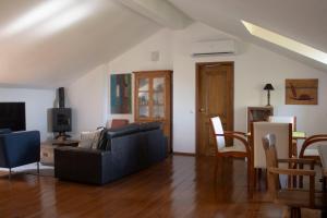 a living room with a black couch and a tv at Casa 7 in Sintra