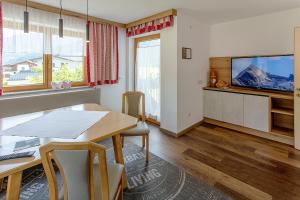 a dining room with a table and a tv at Haus-Elisabeth in Uderns