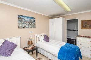 a bedroom with two beds and a dresser at Diamond Style Guesthouse in Gqeberha +33 photos