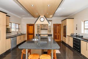 a kitchen with a large island with a clock on it at Diamond Style Guesthouse in Gqeberha