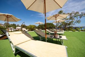 a group of chairs and tables with umbrellas at Pater Meus Suites - Sea View, Pool & Parking in Cefalù